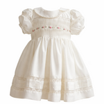White baby girl dress with pintuck bodice and lace hem on hanger