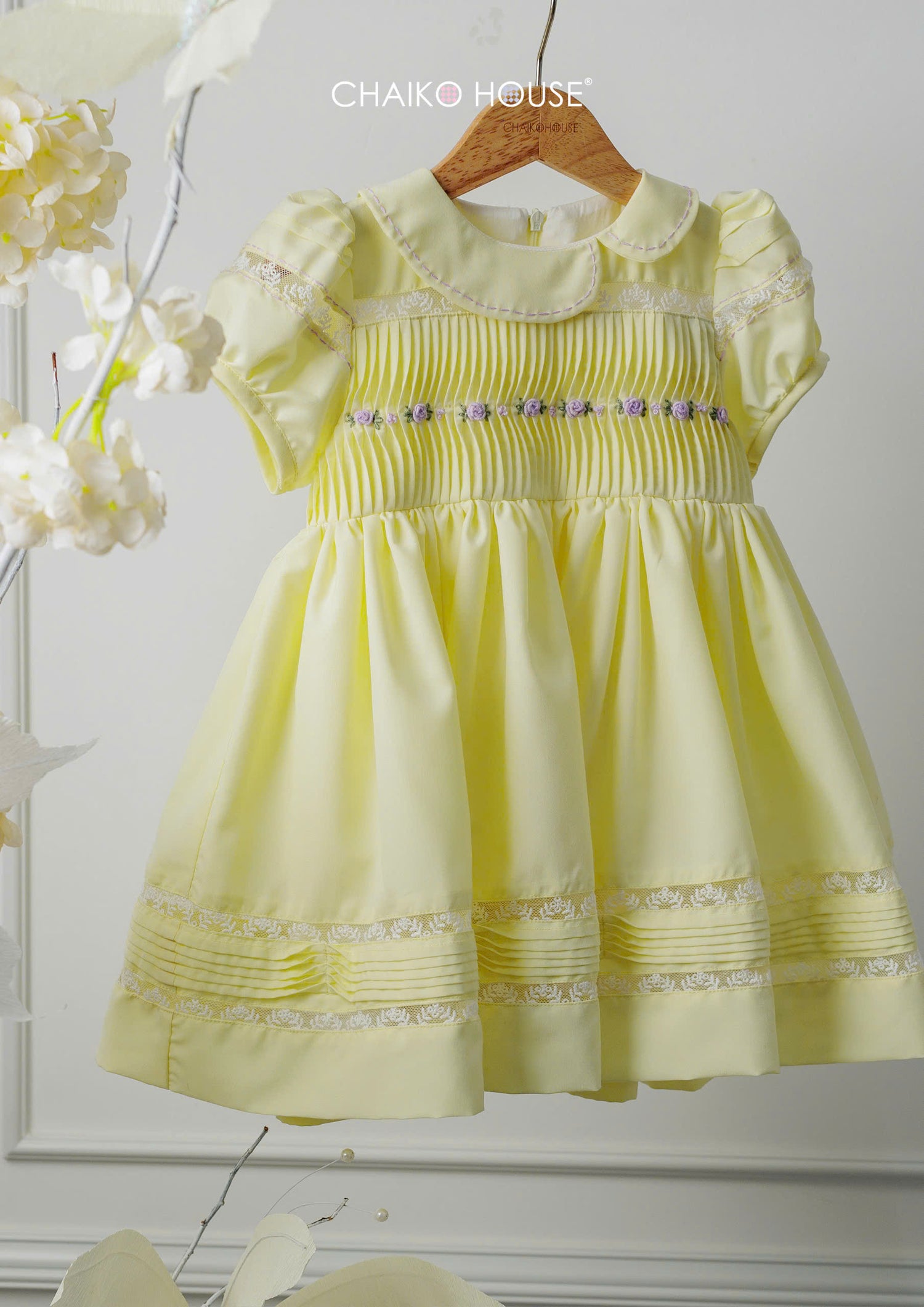 lemon yellow baby girl dress with pintuck bodice and lace hem on hanger