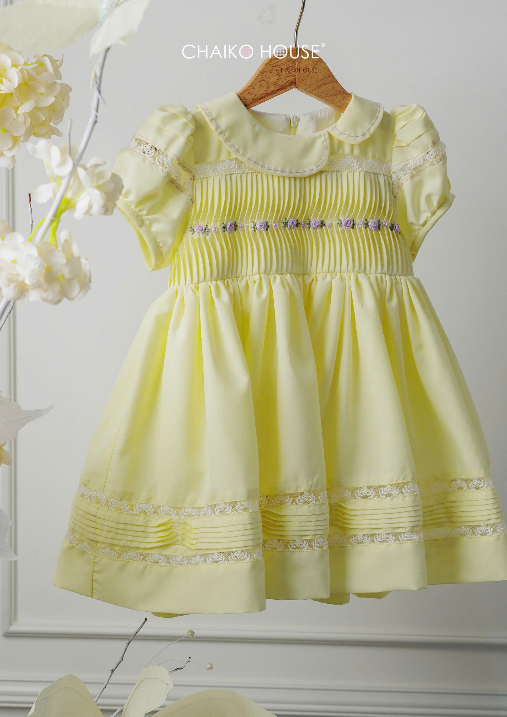 lemon yellow baby girl dress with pintuck bodice and lace hem on hanger