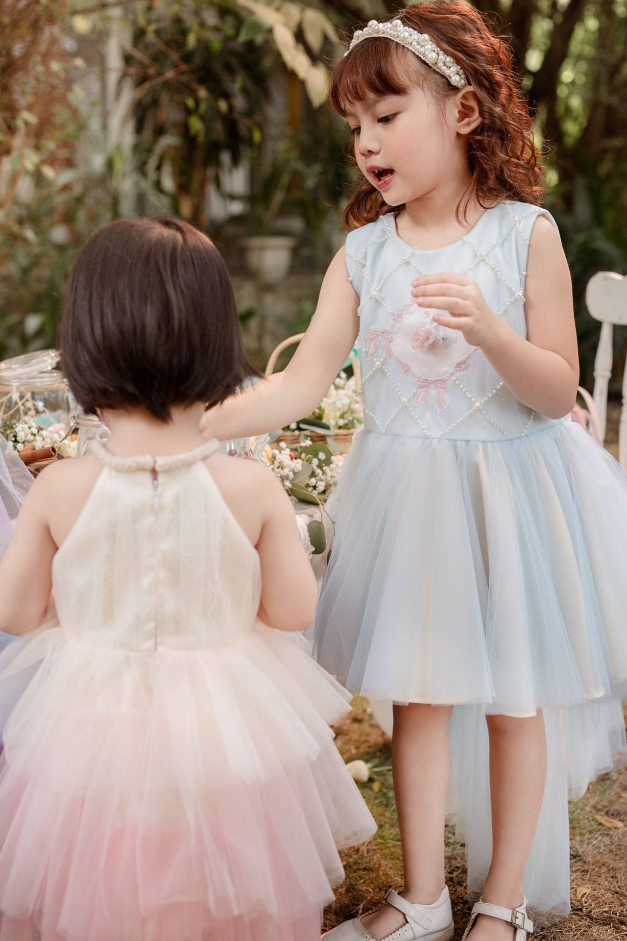 Toddler girl in an elegant tulle dress playing at a birthday or garden party, perfect for special occasions
